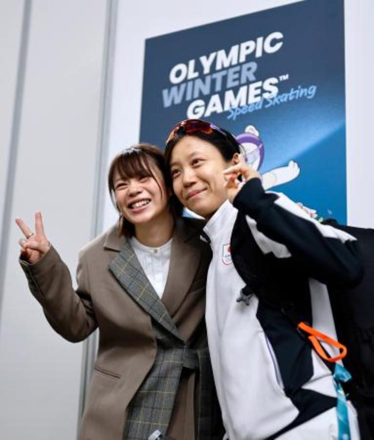 　女子１５００メートルのレースを終え、姉の菜那さん（左）と写真に納まる高木美帆＝ミラノ（共同）