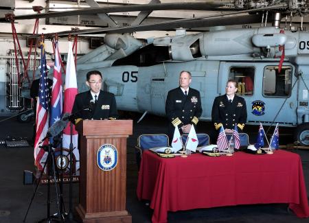 　日米豪の物流協定の署名式に出席した海上自衛隊の星直也装備計画部長（左）ら＝１１日、オーストラリア・ブリスベン（海自のＸから・共同）