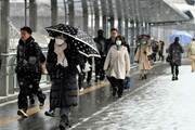 雪が降る中を出勤する人たち＝５日午前７時３５分、岐阜市神田町
