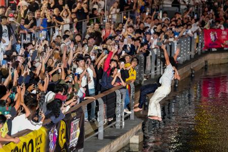 　阪神タイガースがセ・リーグ連覇を決め、大阪・ミナミの道頓堀川に飛び込む人たち＝３日夜