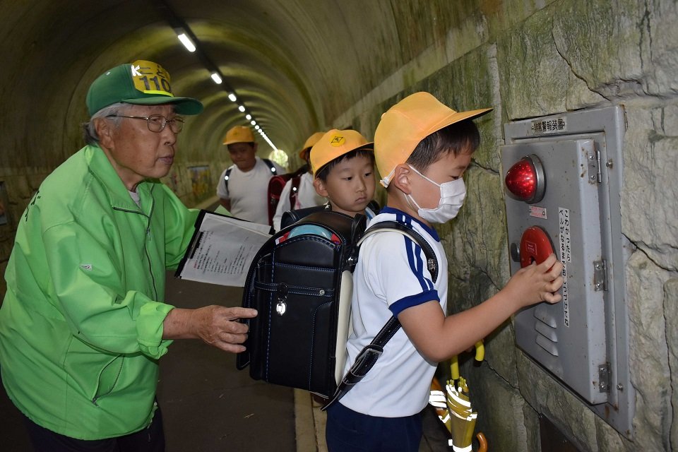 トンネル内の防犯ベルを鳴らす児童＝岐阜市打越
