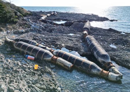 　石川県志賀町の海岸に漂着した鉄製の巨大なホース＝２月２０日（石川県提供）