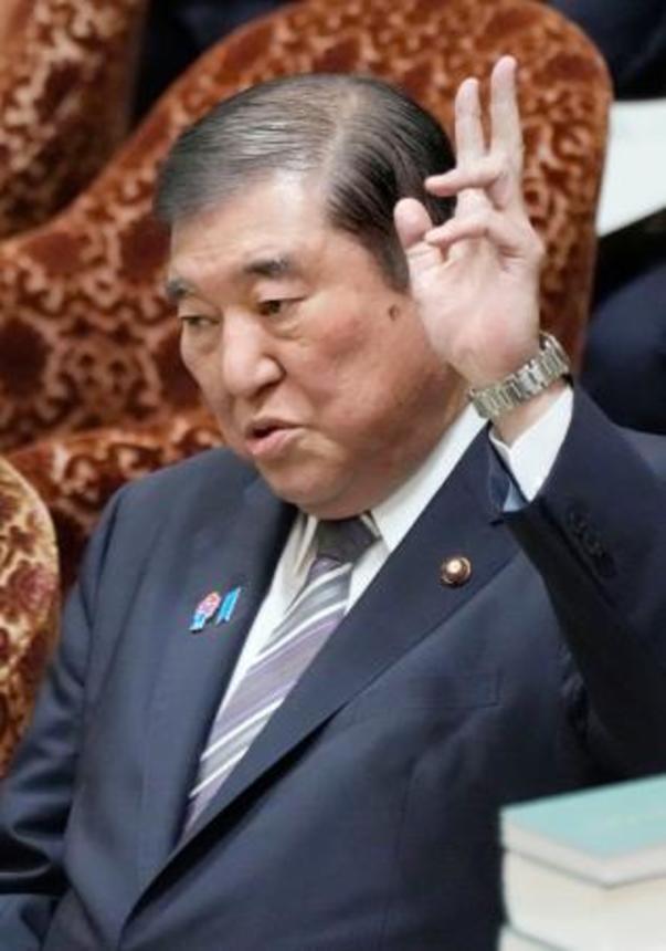 　衆院予算委の集中審議で答弁のため手を挙げる石破首相＝１２日午前