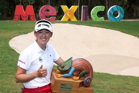 　米女子ゴルフツアーで初優勝を果たし、トロフィーを手に記念撮影に応じる岩井千怜＝２５日、プラヤデルカルメン（ゲッティ＝共同）