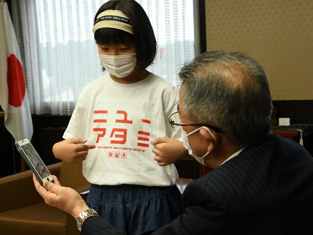 熱海市民からお礼に贈られたＴシャツを身に着け、活動を報告する森安ひばりさん＝高山市役所