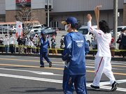 中津川駅前を駆け抜ける加藤拓三さんを応援する沿道の市民ら＝中津川市淀川町