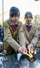 　「１・１７希望の灯り」の分灯が始まり、ろうそくに火を移す中学生＝１０日午後、神戸市中央区の東遊園地
