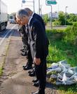 　事故のあった現場に献花し、黙とうする日本クリーンファームの社員ら＝１８日午前、北海道八雲町