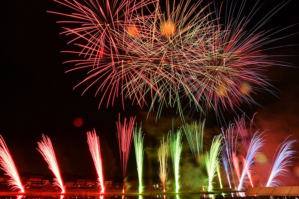 関市の夜空と川面を鮮やかに染めたミュージック花火＝１３日午後８時２分、同市稲口、津保川河畔（撮影・山田雄大）