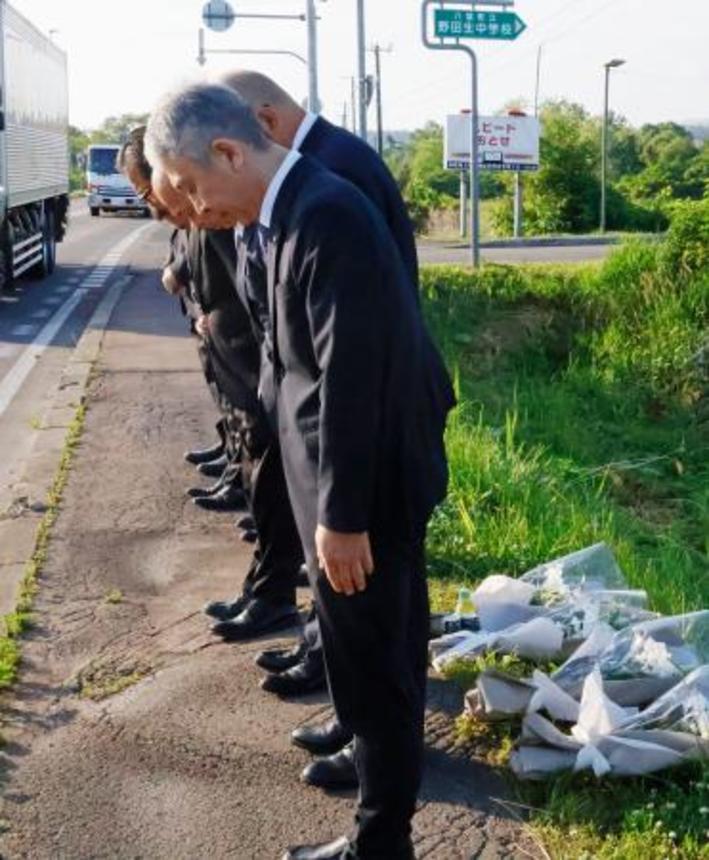 　事故のあった現場に献花し、黙とうする日本クリーンファームの社員ら＝１８日午前、北海道八雲町