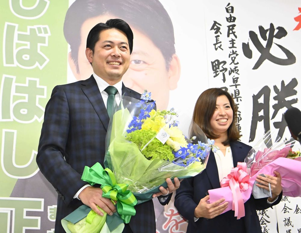 岐阜市長選で再選を確実にして花束を贈られた柴橋正直氏。右は妻有美さん＝６日午後８時１０分、岐阜市端詰町、選挙事務所
