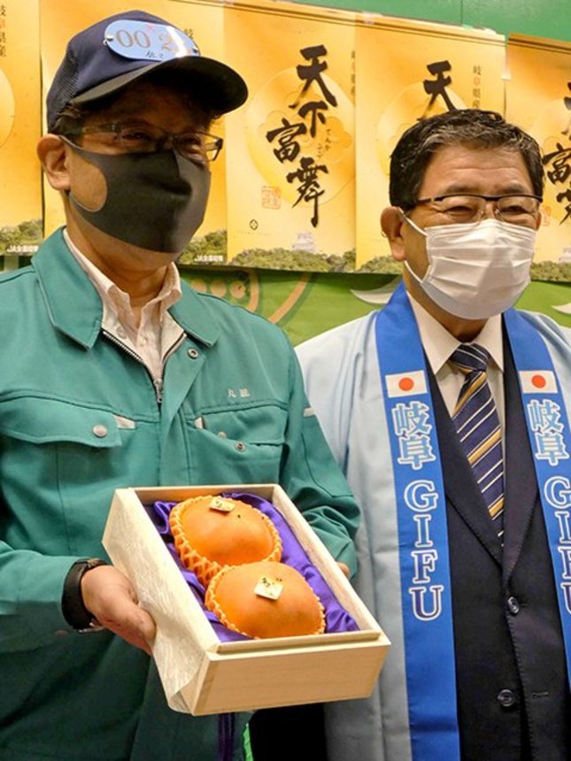 最高等級「天下人」を過去最高の８６万円で落札した丸進青果の関係者（左）と古田肇知事＝２６日午前、愛知県豊山町、名古屋市中央卸売市場北部市場