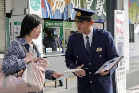 　２０１５年の殺人、放火事件から１０年となり、情報提供を呼びかける神奈川県警小田原署員（右）＝２１日午前、神奈川県湯河原町
