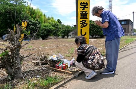 　事故現場付近で夫（右）と手を合わせる鈴木芳江さん＝２８日午前、千葉県八街市