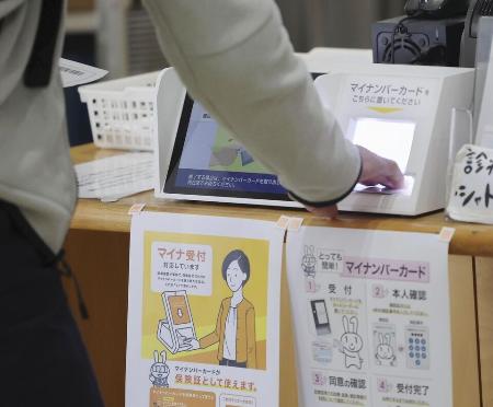 　福岡市内の診療所でマイナカードを使って手続きする人＝２０２４年１２月