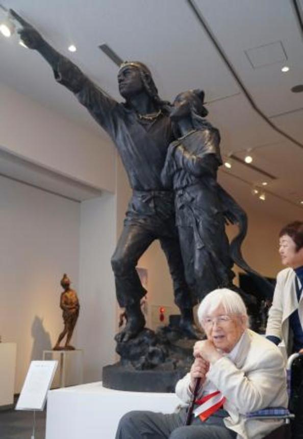 　日本武尊の像の前で記念写真に納まる中村晋也さん＝６日午前、青森県五所川原市