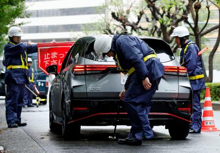 　米大使館周辺で、通行車両の検問を実施する警察官＝２６日午前、東京・赤坂