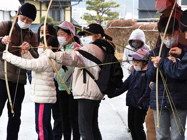 模造の矢を飛ばす子どもたち＝高山市赤保木町、市風土記の丘学習センター