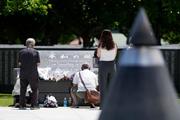 　「慰霊の日」を前に、沖縄戦犠牲者の氏名が刻まれた「平和の礎」に手を合わせる人たち＝２２日午後、沖縄県糸満市の平和祈念公園