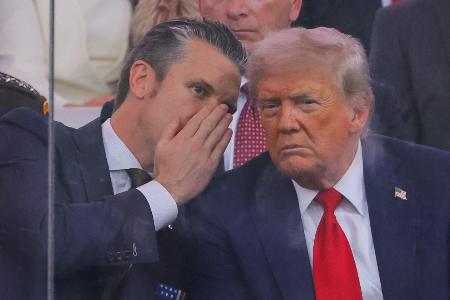 　米ワシントンで行われた軍事パレードの会場で、トランプ大統領（右）と話すヘグセス国防長官＝１４日（ロイター＝共同）