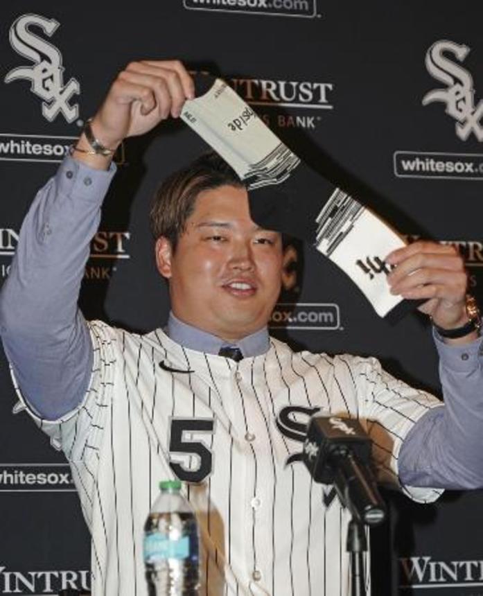 　ホワイトソックスの入団記者会見で靴下を掲げる村上宗隆内野手＝２２日、シカゴ（共同）
