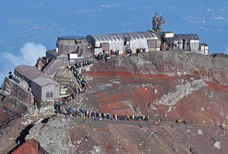 　富士山頂剣ケ峰で記念撮影に並ぶ登山者の行列＝昨年８月（共同通信社ヘリから）