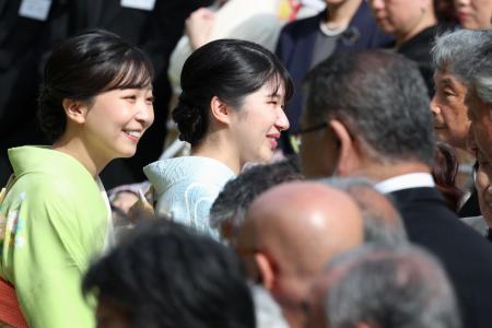　春の園遊会で、招待客らと歓談される愛子さまと秋篠宮家の次女佳子さま＝２２日午後、東京・元赤坂の赤坂御苑（代表撮影）