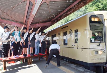 　「くま川鉄道」が全線で運行を再開し、地元の小学生たちの合図で人吉温泉駅を出発する記念特別列車＝２０日午前、熊本県人吉市
