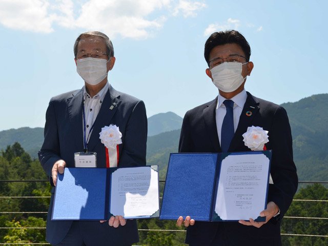 協定書を交わす今井俊郎村長（左）と吉田祐介社長＝加茂郡東白川村神土