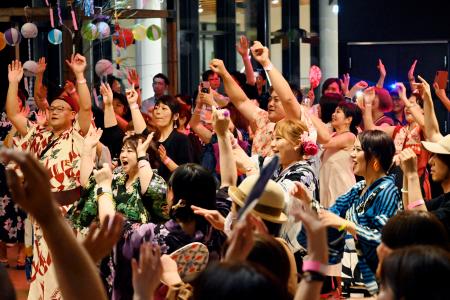 　ＤＪのかけ声に合わせてテンポよく手足を動かし、盆踊りを楽しむ参加者たち＝６日、仙台市