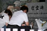 　広島土砂災害から１１年となり、慰霊碑に手を合わせる遺族ら＝２０日未明、広島市安佐南区