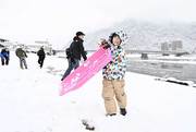 初積雪でそり遊びを楽しむ子ども＝１２日午前８時４９分、岐阜市の長良川堤（撮影・堀尚人）
