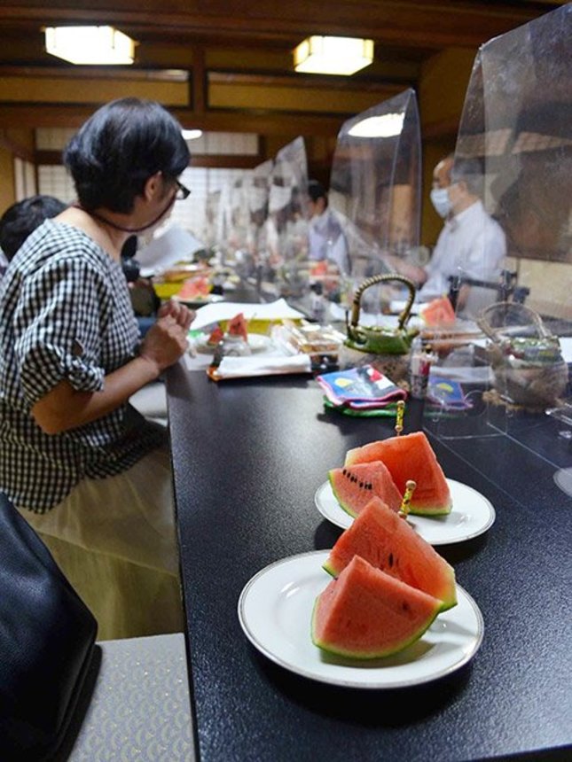 試食をしながら、空中スイカ栽培の手応えを語り合う参加者＝多治見市本町、松正