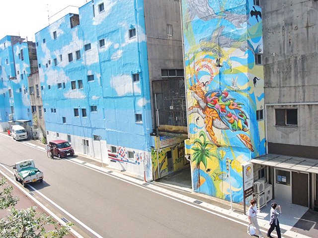 繊維問屋街の一角にお目見えした巨大なウオールアート。スマホ片手に訪れる若者も増えている＝岐阜市問屋町