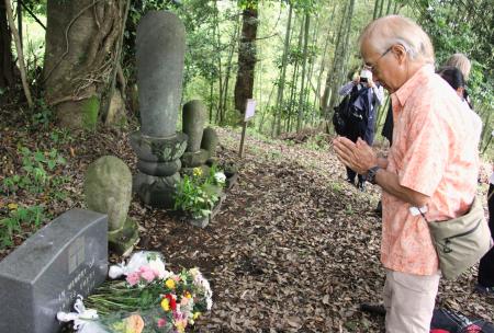 　「神奈川第１抑留所」跡に立つ墓碑に手を合わせる出羽仁さん＝６月、神奈川県南足柄市