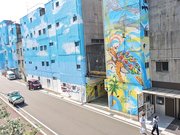 繊維問屋街の一角にお目見えした巨大なウオールアート。スマホ片手に訪れる若者も増えている＝岐阜市問屋町