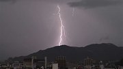 激しい雨とともに走る稲光＝２３日午前１１時２０分、岐阜新聞社本社から岐阜市北部を望む