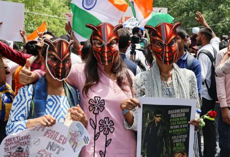　ゴキブリを模したお面をかぶった抗議集会の参加者＝２０日、インド・ニューデリー（共同）