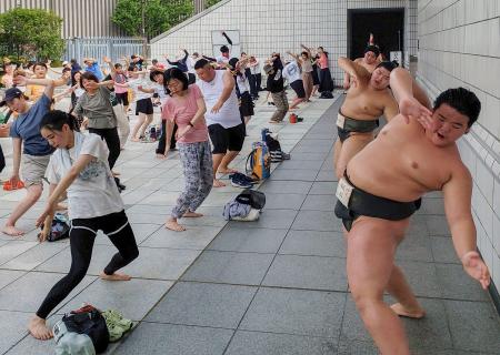 　「夏休み！！相撲健康体操」で、力士と体を動かす参加者＝６日、東京・両国国技館