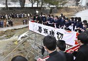 川べりの足場からスカーフを流す卒業生たち＝１日午後０時３９分、岐阜県高山市大新町、大八賀川