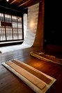 「失われた空間のために、形の先を想像する（仮）」（奥）。手前左がＡＡＩＣで使用したベニヤ板の端材、右が「庭のほつれ」のシイタケ原木＝美濃市泉町、吉田工房