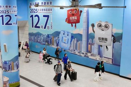 　駅構内の壁一面に張られた立法会選挙の投票を呼びかける広告＝６日、香港（共同）