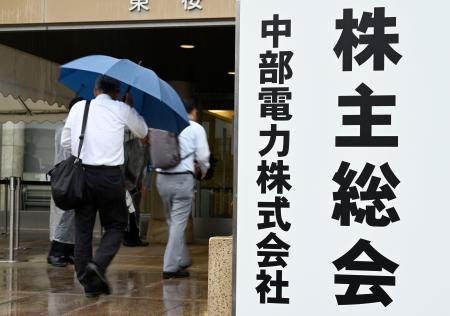　中部電力の定時株主総会の会場へ向かう人たち＝２５日午前、名古屋市