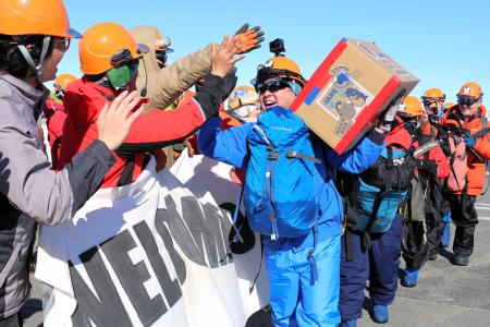 　昭和基地に到着し、６６次越冬隊員（左）に出迎えられる第６７次南極地域観測隊員＝２５日（南極観測隊同行記者撮影）