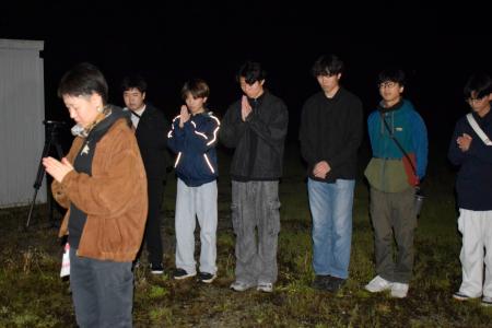 　東海大生が犠牲になったアパート倒壊現場で手を合わせる卒業生の橋村さくらさん（左端）と現役学生ら＝１６日未明、熊本県南阿蘇村