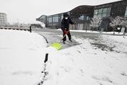 岐阜市の今季初積雪を受け広場の雪かきをする人＝２７日午前１０時１１分、岐阜市司町	