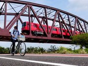 名鉄名古屋本線の鉄橋をくぐって走る記者。鉄道ファンにもお薦めの構図だ＝羽島郡笠松町相生町