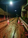 鴬谷トンネル付近の県道脇の斜面が崩れ、流れ出た土砂＝２５日午後９時３０分、岐阜市鴬谷町