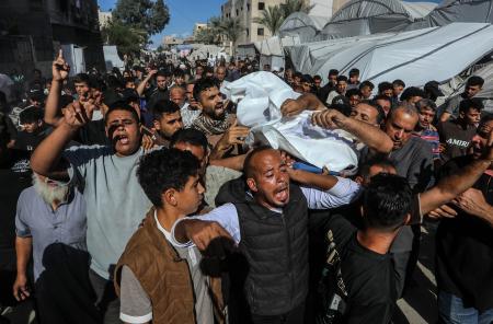 　イスラエル軍の攻撃で死亡した１６歳の少年の遺体を運ぶ人たち＝７日、パレスチナ自治区ガザ南部ハンユニス（ゲッティ＝共同）