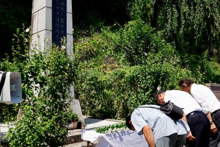 　松代大本営の朝鮮人追悼碑に献花した参列者たち＝１０日午前、長野市
